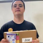 A boy holding a box and chocolate bar